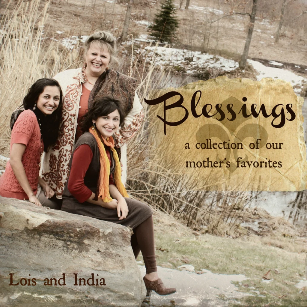 Cover art for "Blessings". It shows Lois, India, and their mother sitting on a large rock surrounded by tall grasses and trees.