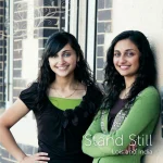 Album cover for "Stand Still". Shows Lois and India with backs against a windowed wall.