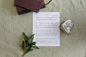 Sheet music to "A Missionary". The music is surrounded by a model piano, a bible, and a small leafy plant.