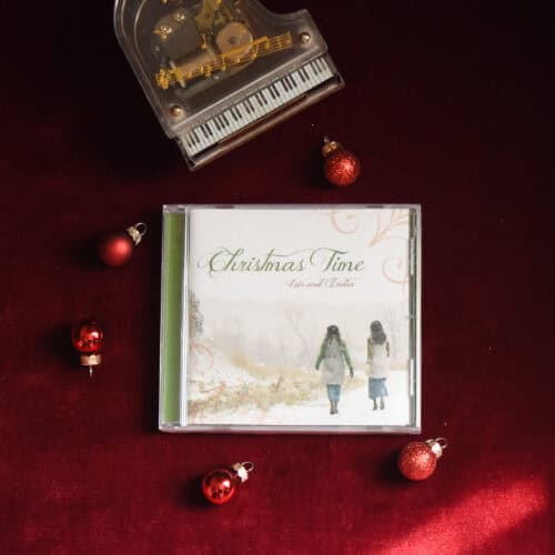 CD of "Christmas Time". The music is surrounded by a model piano and Christmas Bulbs on a red background.