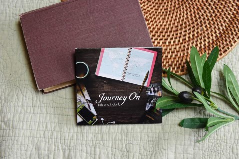CD of "Journey On". The music is surrounded by a bible, and a small leafy plant.