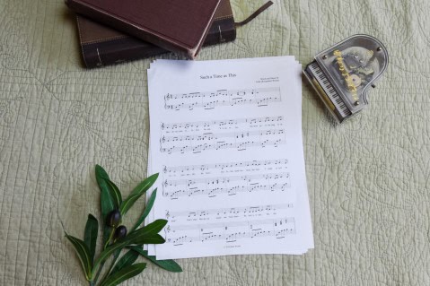 Sheet music to "For Such A Time As This". The music is surrounded by a model piano, a bible, and a small leafy plant.