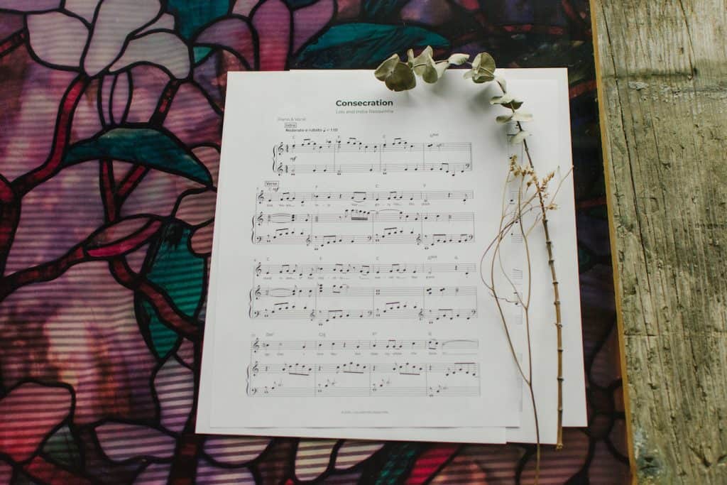 Sheet Music to "Consecration" laying on a table with flowers around it.