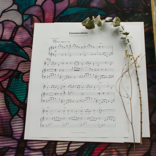 Sheet Music to "Consecration" laying on a table with flowers around it.