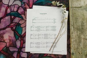 The sheet music to "Gospel Hymn" laying on a table surrounded by flowers.