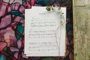 Sheet music to "Grace in me" laying on a table surrounded by floral arrangements.