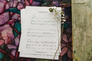 Sheet music to "Impossible Grace" laying on a table surrounded by floral arrangements